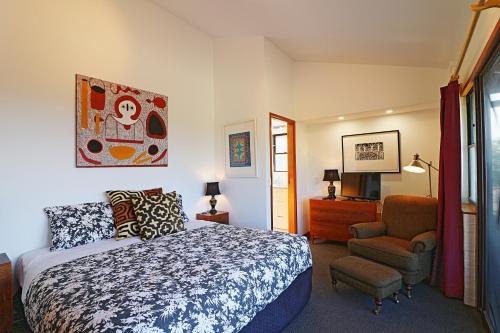 a bedroom with a bed and a chair at Seavista 2 in Pambula Beach