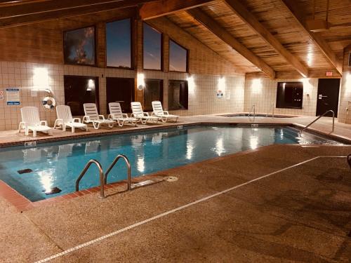 a large swimming pool with white chairs at Regency Inn and Suites in Stilwell