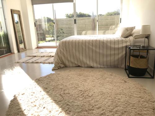 a bedroom with a bed and a rug on the floor at Loft de Mar in José Ignacio