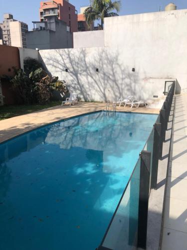 a swimming pool with blue water in front of a building at Alquiler temporario tucuman barrio norte 1 in San Miguel de Tucumán