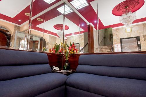 a waiting room with blue chairs and a mirror at Hotel Acapulco in Panama City
