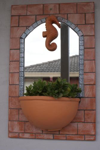 a brick wall with a flower pot and a window at Karuah Riverside Motel in Karuah