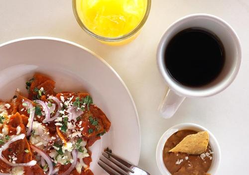 a table with a plate of food and a cup of coffee at Stella del Mar in San Felipe