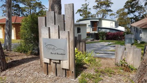 a sign on a wooden fence in front of a house at The Edgewater on Greville in Sanctuary Point