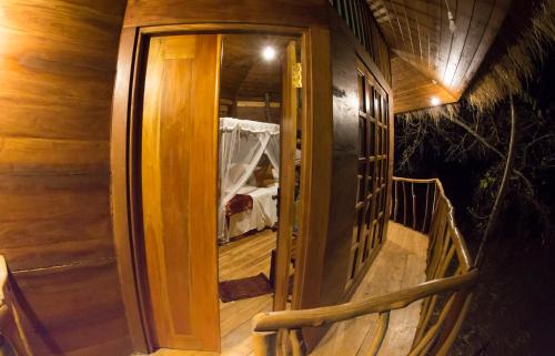 a wooden door leading to a room with a bed at La Pentera in Hambegamuwa
