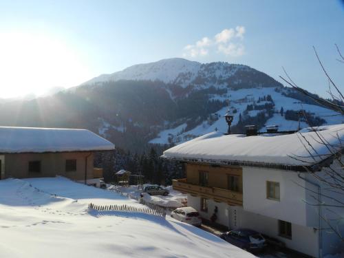 a snow covered building with a mountain in the background at Grillinghof in Kirchberg in Tirol