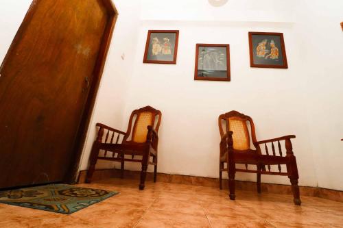 two chairs in a room with pictures on the wall at Sudumal Cottage in Ella