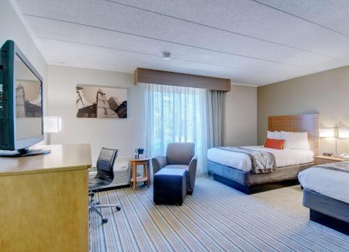 a hotel room with a bed and a television at Best Western Plus Waltham Boston in Waltham