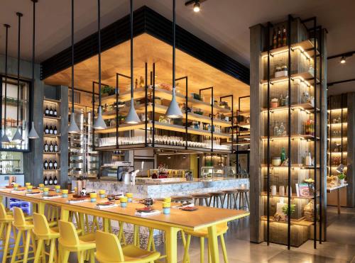 a restaurant with a long table and yellow chairs at Grand Hyatt Abu Dhabi Hotel & Residences Emirates Pearl in Abu Dhabi