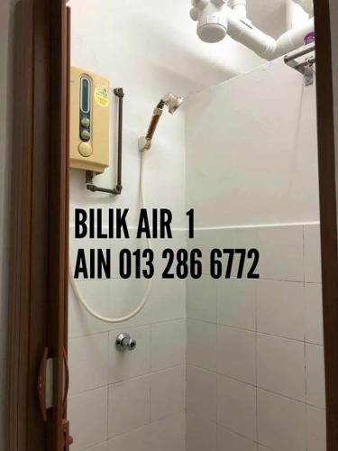 a bathroom with a shower with a sign on the wall at Rumah Chewaa Homestay in Kuala Lumpur