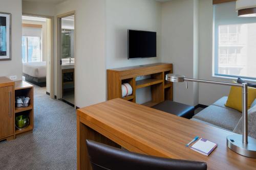 a living room with a desk and chairs at Hyatt Place Long Island City in Queens