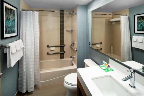 a bathroom with a tub and a toilet and a sink at Hyatt Place Long Island City in Queens