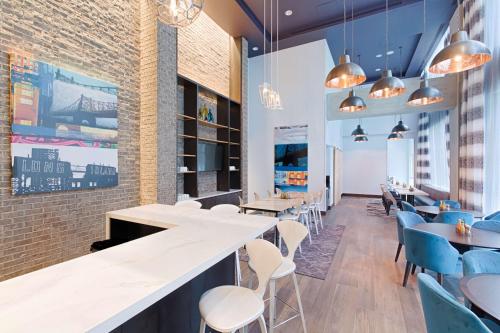 a restaurant with white tables and chairs at Hyatt Place Long Island City in Queens