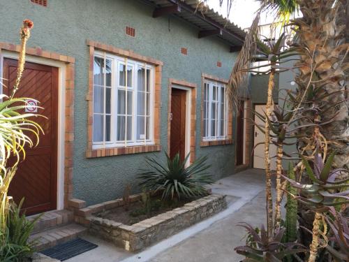 una casa verde con una puerta y algunas plantas en Tranquility Self Catering en Lüderitz