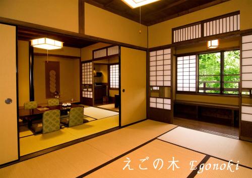 sala de estar con paredes amarillas, mesa y sillas en Ryokan Sanga en Minamioguni