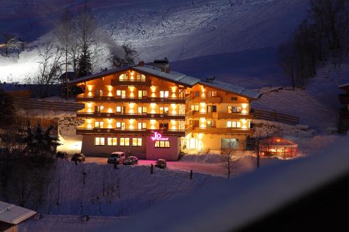 a large building with lights in the snow at night at Johanneshof - Dein MOUNTAIN Wohlfühlhotel in Saalbach Hinterglemm