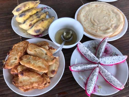 a table with plates of food and a cup of coffee at Dao Homestay in Hoàng Su Phì