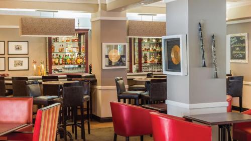 a restaurant with tables and chairs and a bar at Southern Sun Ridgeway Lusaka in Lusaka