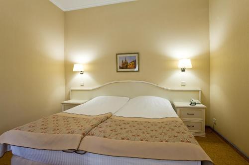 a bedroom with a large bed with two pillows at Cameo Hotel in Saint Petersburg
