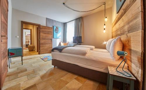 ザールバッハ・ヒンターグレムにあるLALA home Chalet & Appartementの大きなベッドとデスクが備わるホテルルームです。