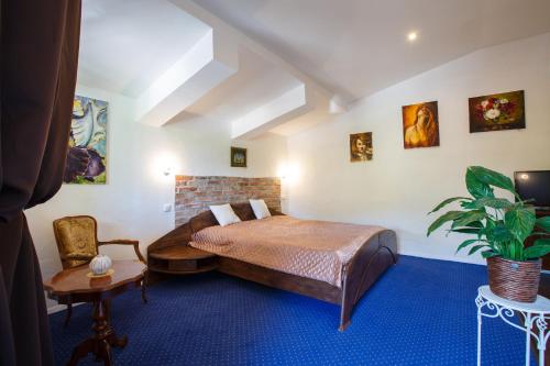 a bedroom with a bed and a chair in a room at Penzión ARTin in Nitra