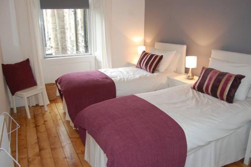 een slaapkamer met twee bedden en een raam bij Home from Home at Number 2 in Edinburgh