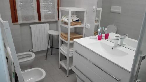 Baño blanco con lavabo y aseo en il Gelsomino appartamento turistico, en Pesaro