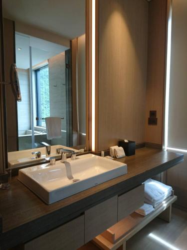 a bathroom with a large white sink and a mirror at MU Jiaoxi Hotel in Jiaoxi