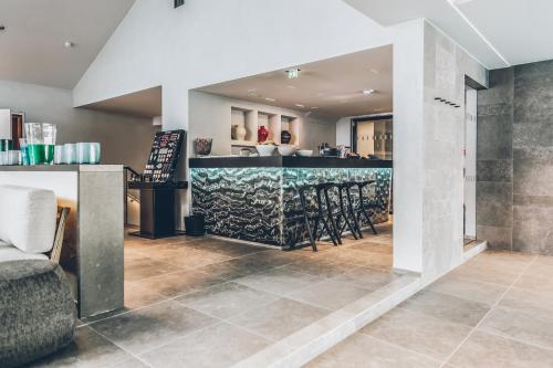 a bar in a room with a counter and chairs at Elizabeth Arthotel Adults Only in Ischgl