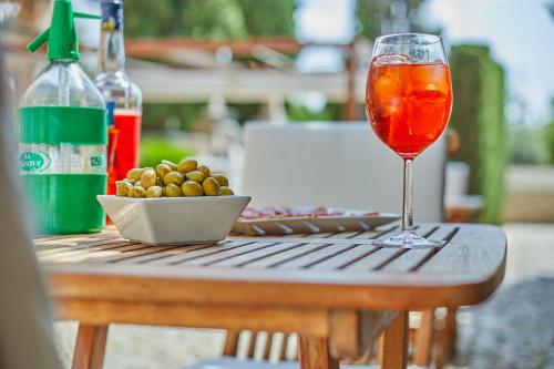 a glass of wine and a bowl of olives on a table at Cas Comte Suites & Spa - Adults Only in Lloseta