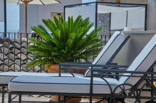 a pair of chairs on a balcony with a plant at Cas Comte Suites & Spa - Adults Only in Lloseta