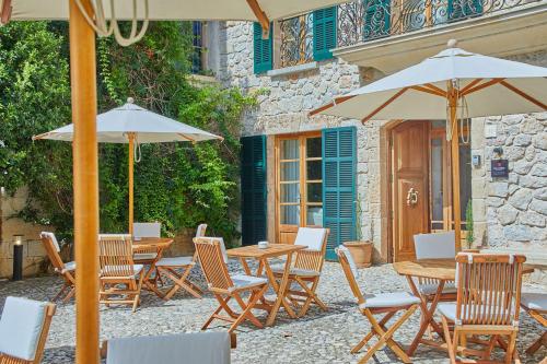 a group of tables and chairs with umbrellas at Cas Comte Suites & Spa - Adults Only in Lloseta