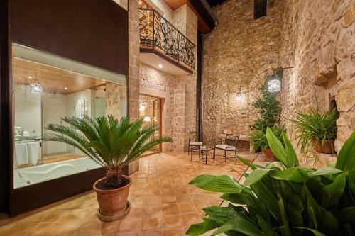 baño grande con bañera y plantas. en Cas Comte Suites & Spa - Adults Only, en Lloseta