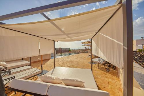 a patio with a white couch and a canopy at Cas Comte Suites & Spa - Adults Only in Lloseta