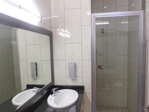 a bathroom with a sink and a shower at The Links Guest House in Pretoria