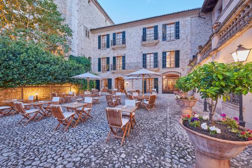 a patio with tables and chairs in front of a building at Cas Comte Suites & Spa - Adults Only in Lloseta