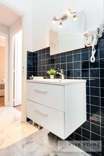 - une cuisine blanche avec un mur carrelé noir dans l'établissement Suite Gioia five stars holiday house, à Nice