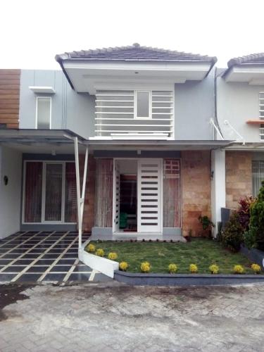 una casa con césped delante en Vila Monex en Batu
