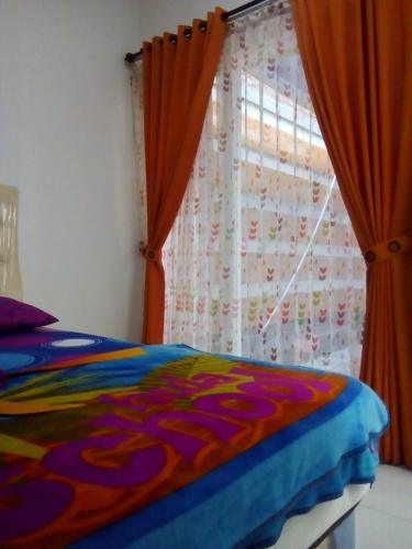 1 dormitorio con 1 cama y una ventana con cortinas en Vila Monex en Batu