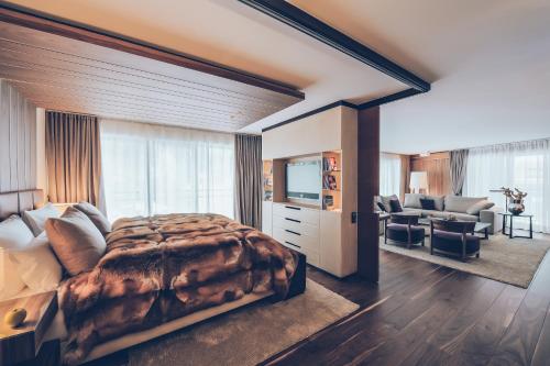 ein Schlafzimmer mit einem großen Bett und ein Wohnzimmer in der Unterkunft Elizabeth Arthotel in Ischgl