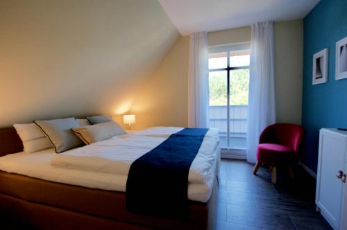 a bedroom with a large bed and a window at Haus Meerblau in Born