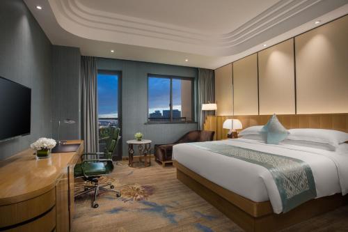 a hotel room with a bed and a desk and a computer at Wyndham HangZhou East in Hangzhou