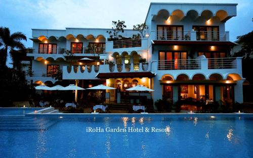 a hotel with a swimming pool in front of a building at iRoHa Garden Hotel & Resort in Phnom Penh