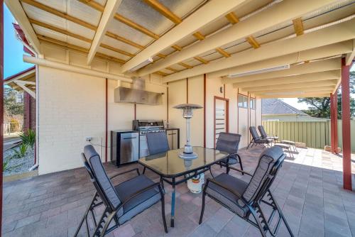 a patio with a table and chairs on a patio at Marulan Stayz in Marulan