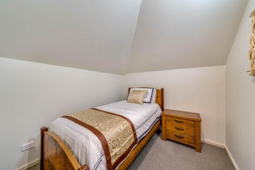 a small bedroom with a bed and a wooden nightstand at Marulan Stayz in Marulan