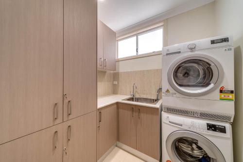 a kitchen with a washing machine and a sink at Marulan Stayz in Marulan