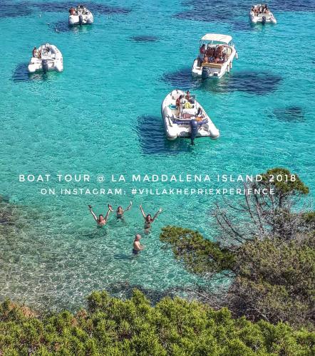 a group of people swimming in the water on boats at Villa Khepri in Porto Rotondo