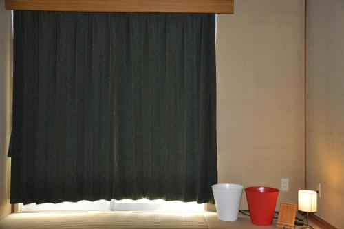 a dark green curtain in a room with a toilet at Tuktuk House in Kawagoe