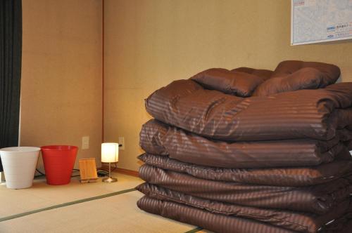 a stack of leather chairs sitting in a room at Tuktuk House in Kawagoe
