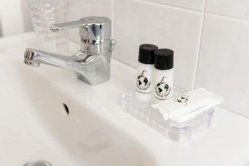 un lavandino con rubinetto e due bottiglie di Bellavista Flat - The House Of Travelers a Como